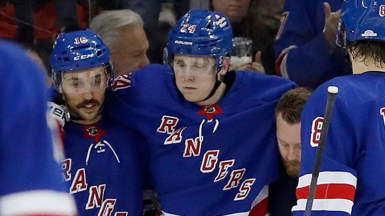 Kaapo Kakko of the Rangers is helped off the ice after...