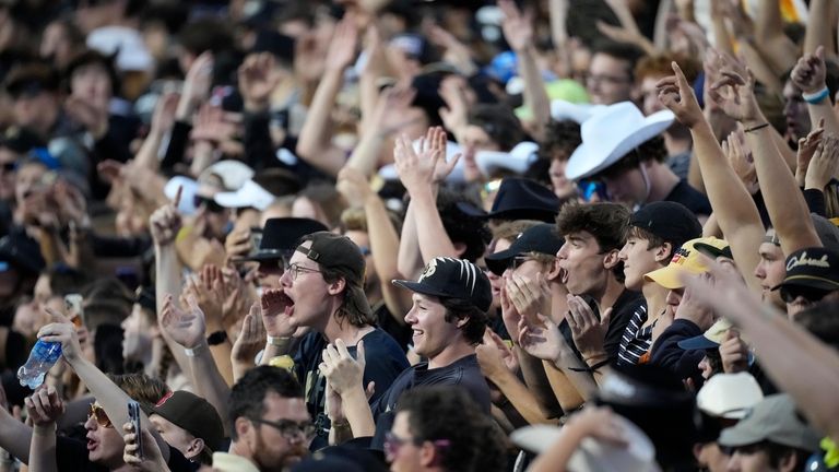 Colorado fans cheer as players warm up before an NCAA...