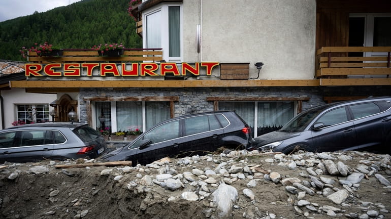 Cars stuck in the rubble from a landslide caused by...