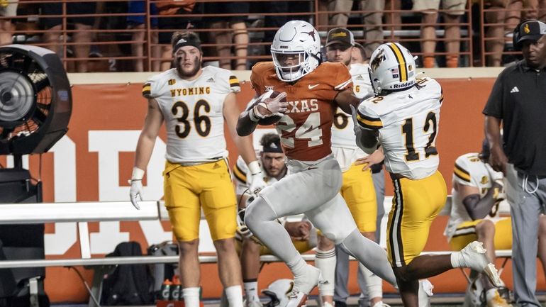 Texas running back Jonathon Brooks (24) carries past Wyoming's Chauncey...