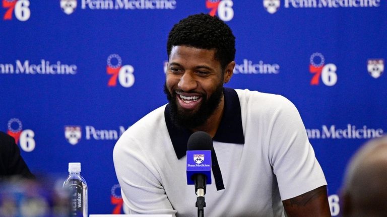 Philadelphia 76ers' Paul George smiles as he speaks with members...