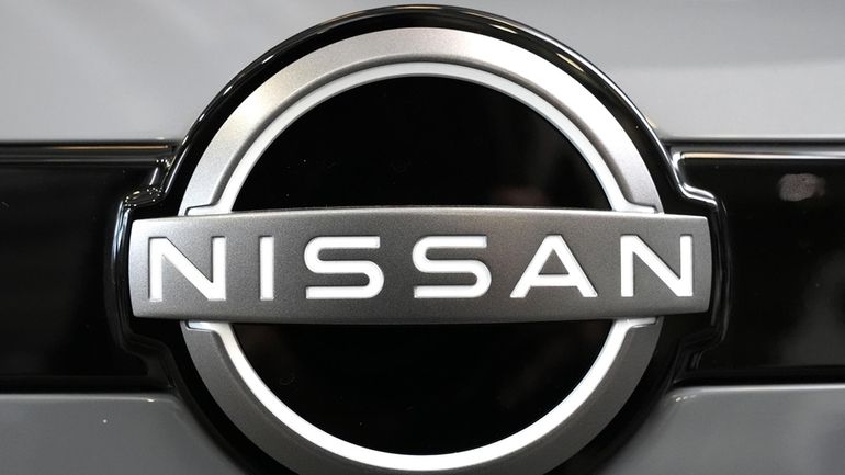 A Nissan logo is displayed on a Nissan Pathfinder SUV...