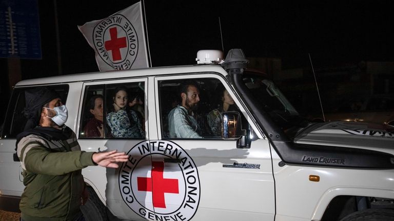 A Red Cross vehicle carrying Israeli hostages drives by at...