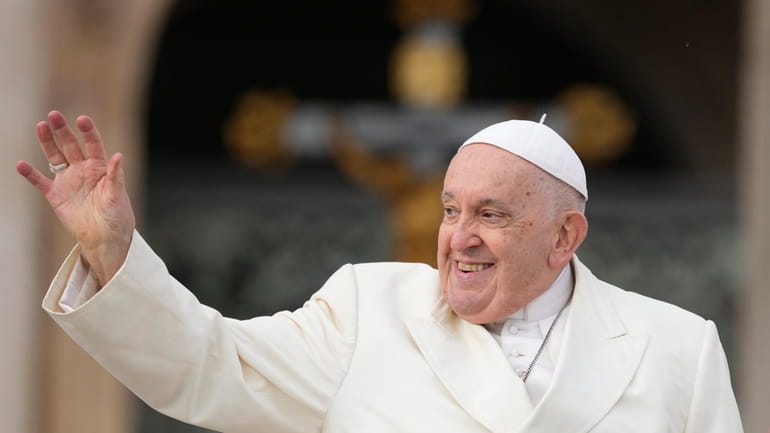 Pope Francis smiles as he waves faithful at the end...