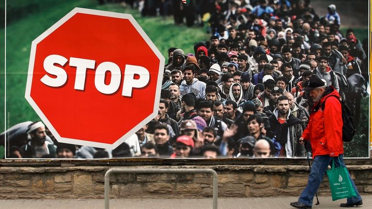 A man walks by an anti-migration billboard from the Hungarian...