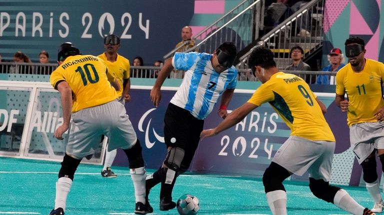 Argentina's Maximiliano Espinillo fights for the ball against Brazil's Ricardinho,...