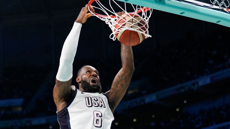 LeBron James, of the United States, gets a basket on...