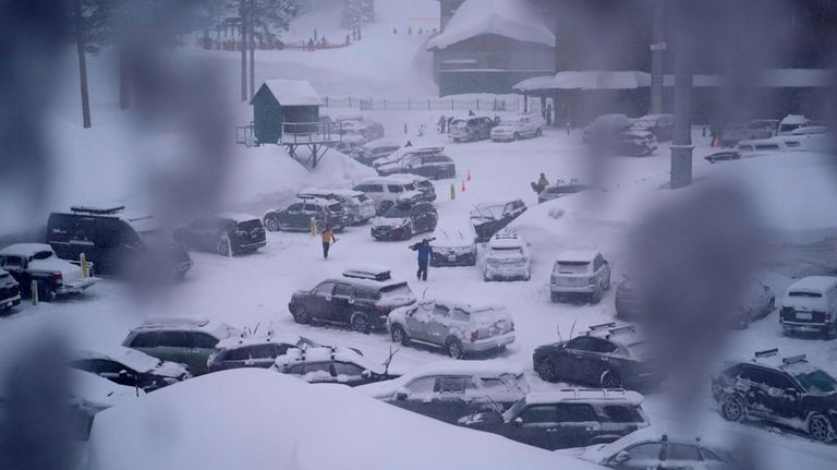 People through the parking area of the Alpine Base Area...