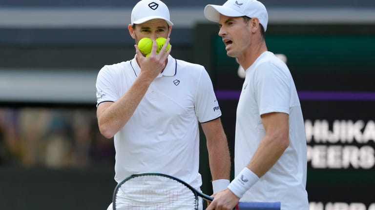 Andy, right, and Jamie Murray talk during their first round...