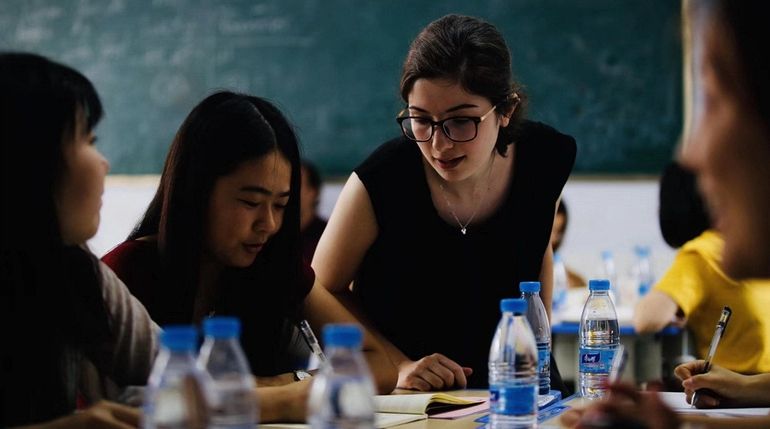 Volunteer Jessica Williams, center, teaches English during the Peace Corps...