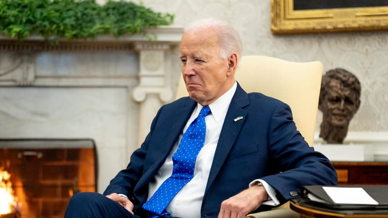 President Joe Biden sits in the Oval Office of the...