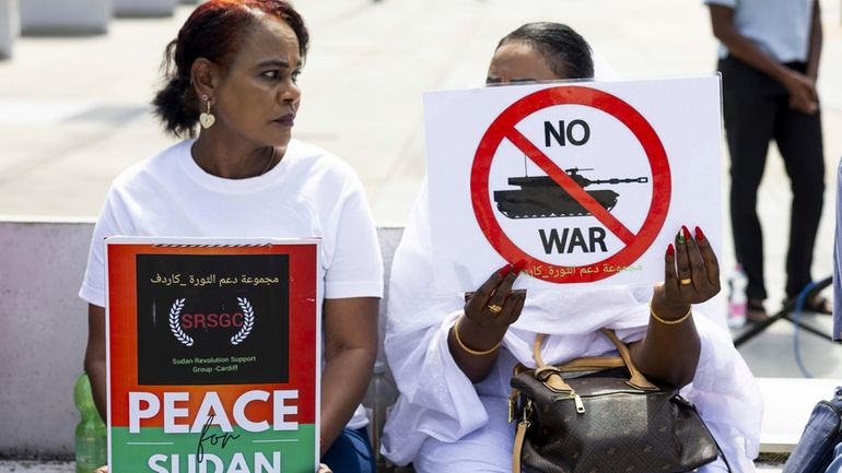 Demonstrators hold signs during a rally, on the opening day...