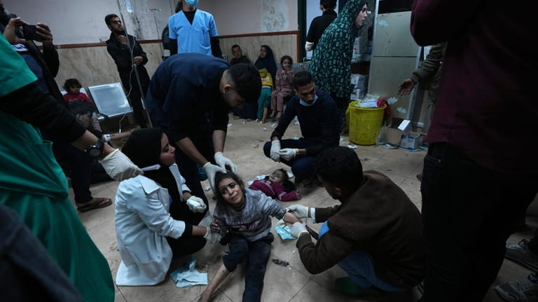 Palestinians wounded in the Israeli bombardment of the Gaza Strip...