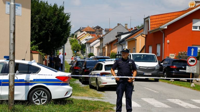 A police officer stands near the crime scene in Daruvar,...