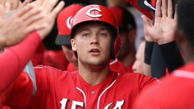 The Reds' Nick Senzel celebrates his run scored against the Indians...