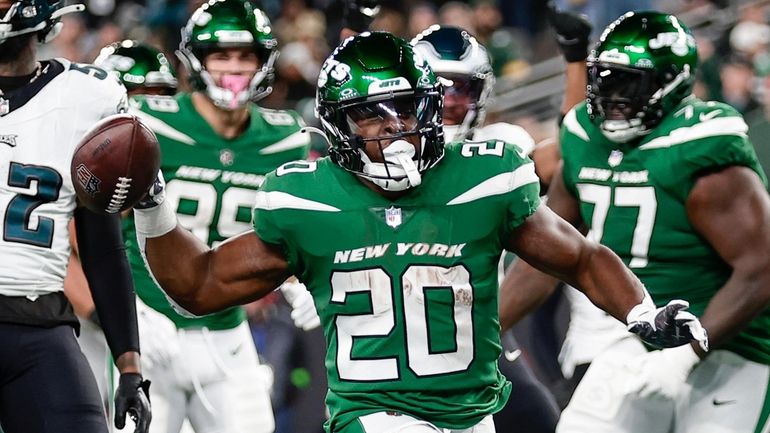 New York Jets' Breece Hall, center, reacts after scoring a...