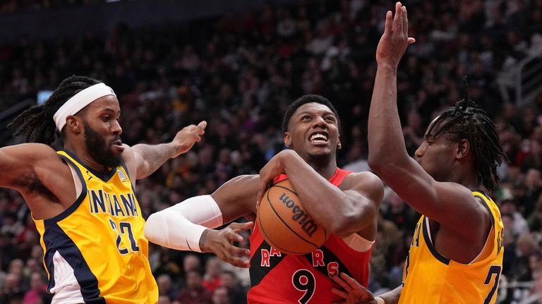 Toronto Raptors guard RJ Barrett, center, drives between Indiana Pacers...