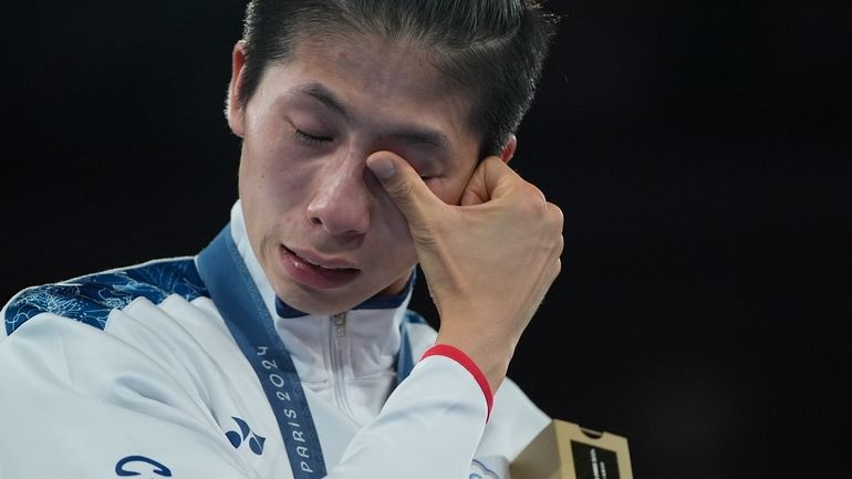 Gold medalist Taiwan's Lin Yu-ting wipes tears during a medals...