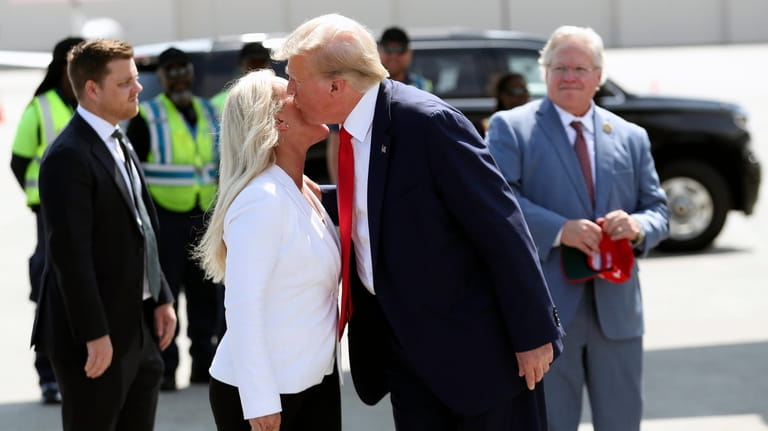 Former President Donald Trump is greeted by Rep. Majorie Taylor...