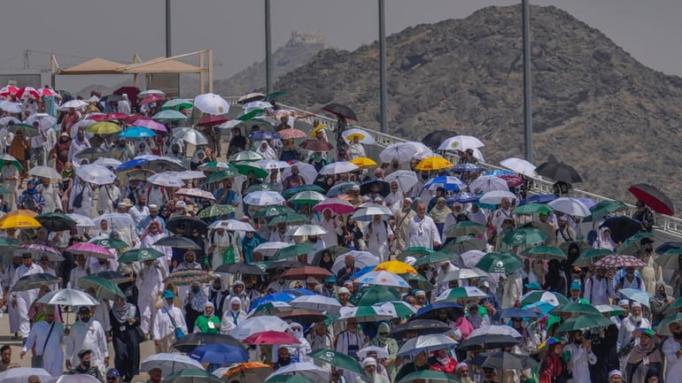 Muslim pilgrims use umbrellas to shield themselves from the sun...