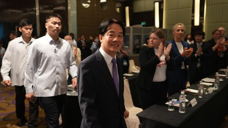 Taiwanese President Lai Ching-te, center, arrives to speak at a...