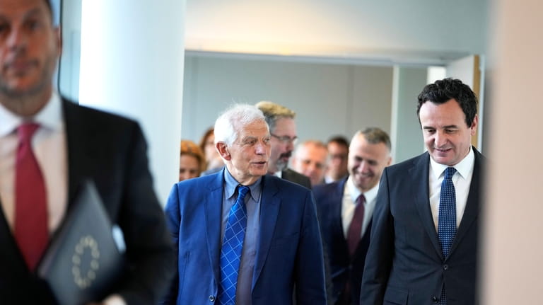 Kosovo's Prime Minister Albin Kurti, right, walks with European Union...