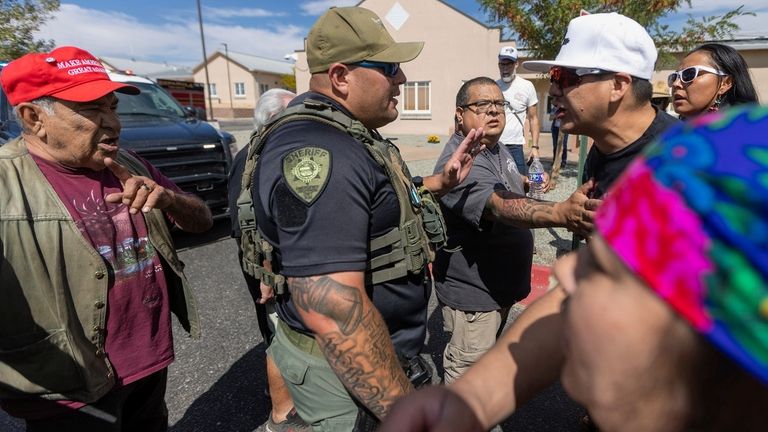 A law enforcement officer stands as protestors clash at the...