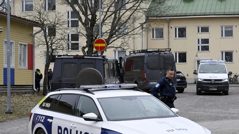 Police officers and vehicles at the scene of Viertola comprehensive...