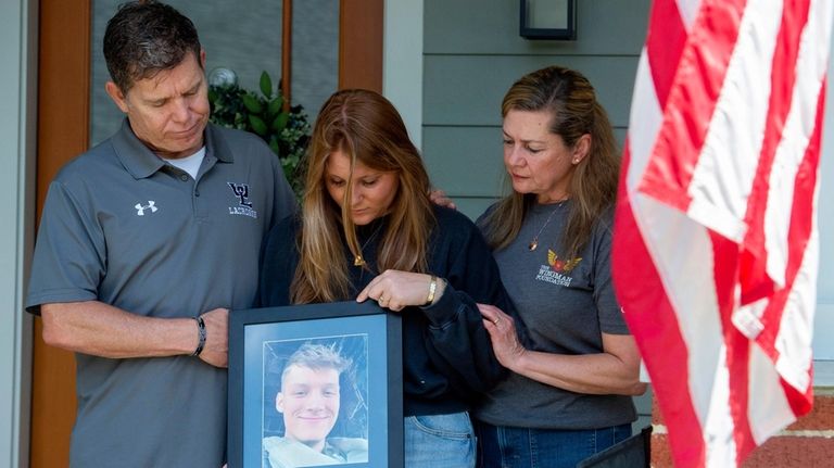 Family members of Marine Corporal Spencer R. Collart, from left,...