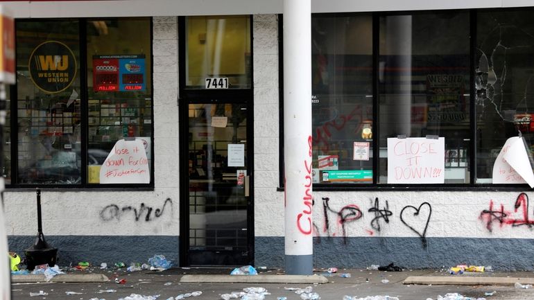 Debris is spread out in front of a convenience store,...