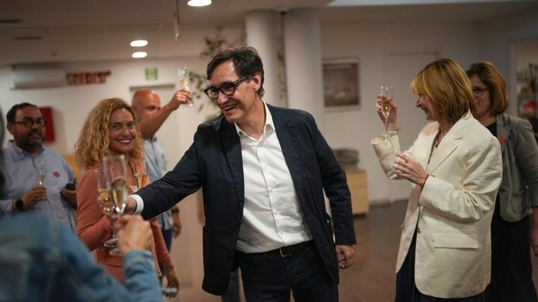 Socialist candidate Salvador Illa makes a toast with his members...