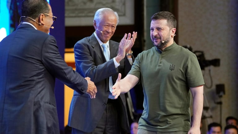 Ukraine's President Volodymyr Zelenskyy, right, shakes hand with Malaysian Defense...