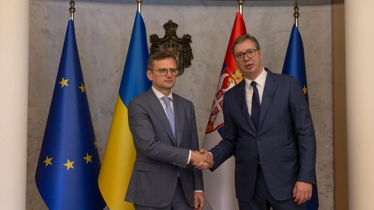 Serbian President Aleksandar Vucic, right, shakes hands with Ukraine's Foreign...