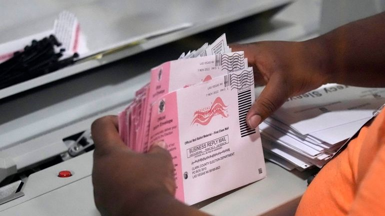 An election worker prepares mail-in ballots at the Clark County...