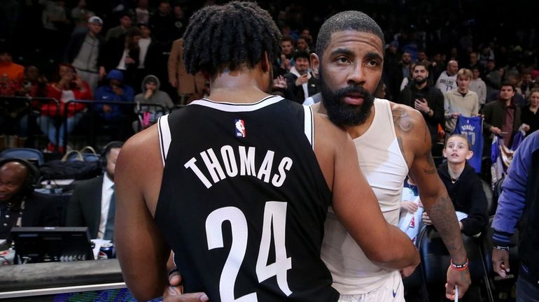 Mavericks guard Kyrie Irving hugs Nets guard Cam Thomas after their...