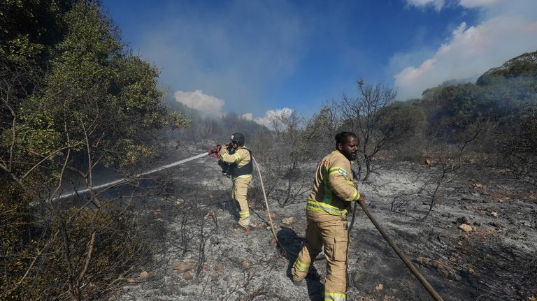 Israeli firefighters work to extinguish a fire after a rocket...