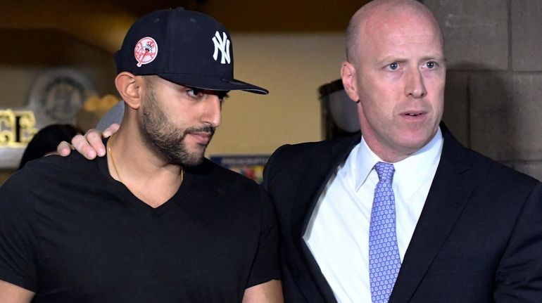 Nauman Hussain, left, leaves Cobleskill Town court with his attorney...