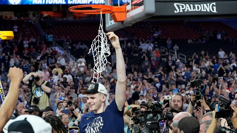 UConn center Donovan Clingan (32) celebrates cutting the net after...