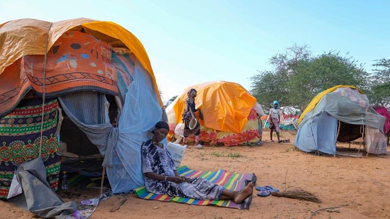 A Internally displaced woman sits outside her makeshift shelter at...