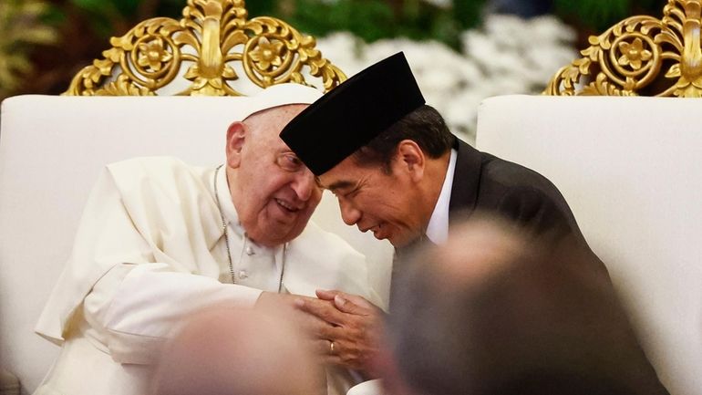 Pope Francis, left, and Indonesian President Joko Widodo attend a...