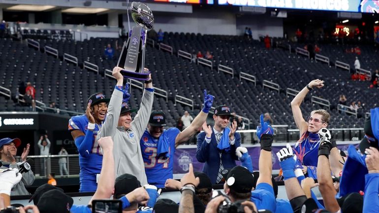 Boise State interim head coach Spencer Danielson holds up the...