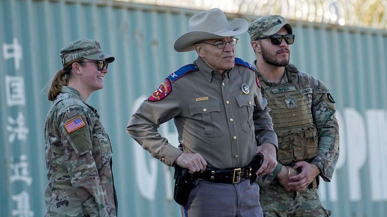 Texas Department of Public Safety Chief Steve McCraw, center, stands...