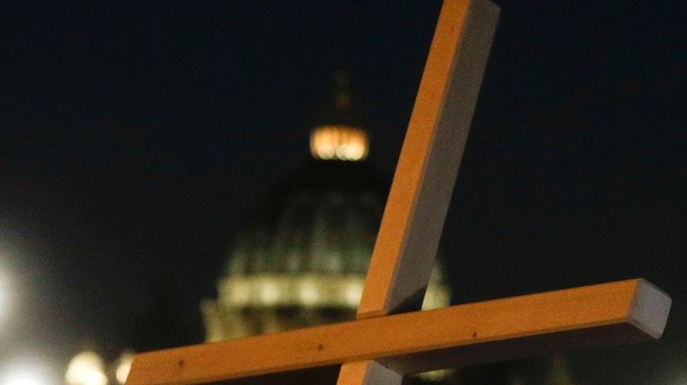 Survivors of sex abuse hold a cross as they gather...