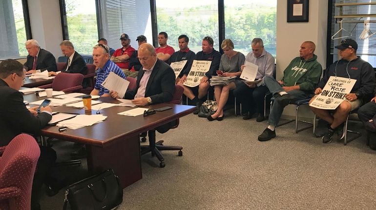 Striking employees of beer distributor Clare Rose attend a meeting...