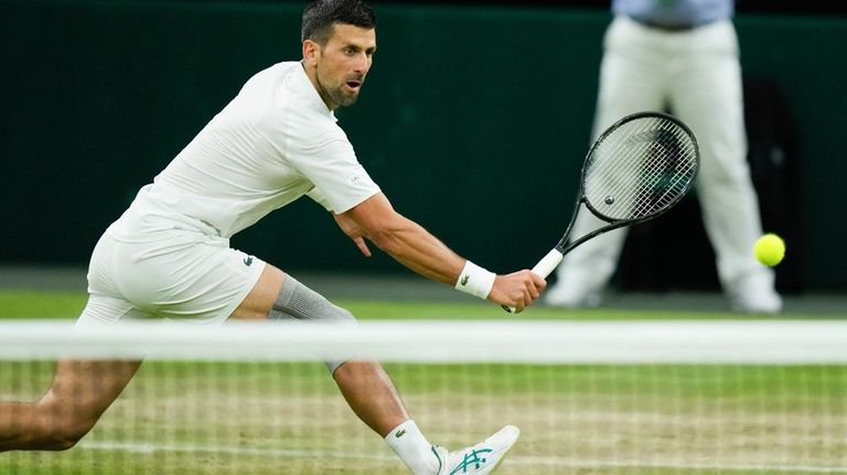 Novak Djokovic of Serbia plays a backhand return to Holger...