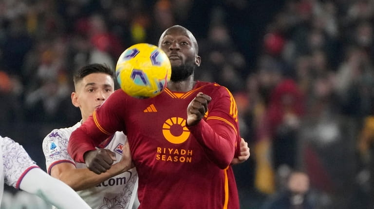 Roma's Romelu Lukaku, right, challenges for the ball with Fiorentina's...