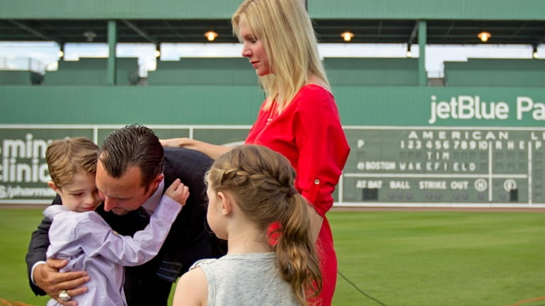 Boston Red Sox pitcher Tim Wakefield, center left, hugs his...