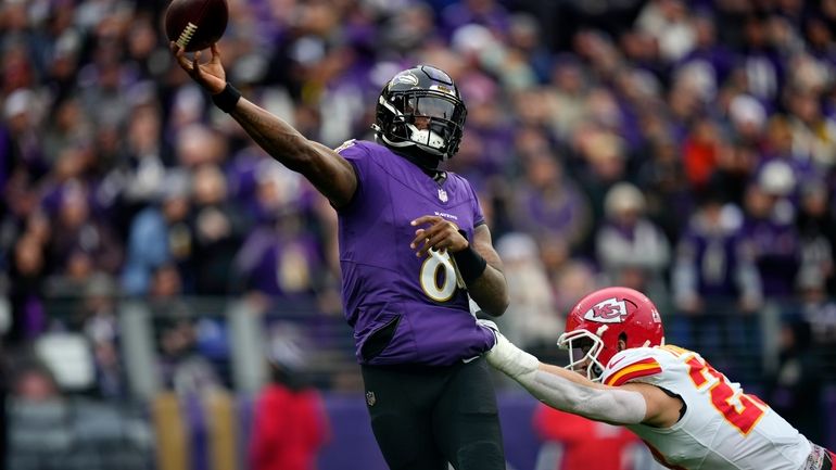 Baltimore Ravens' Lamar Jackson gets off a pass during the...