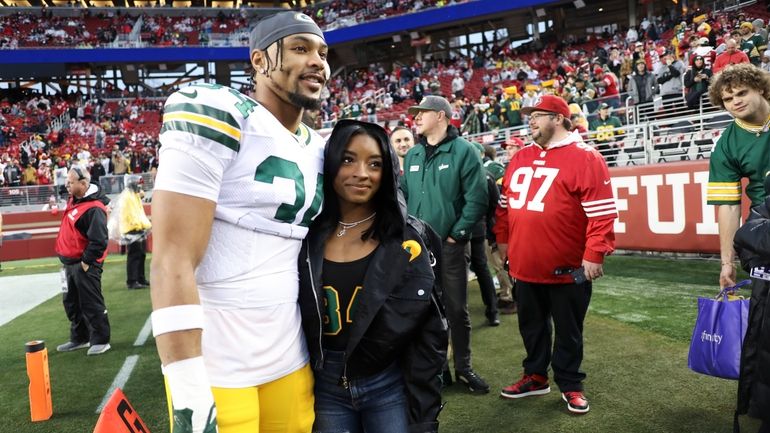 Then-Green Bay Packers' Jonathan Owens (34) and Simone Biles pose...