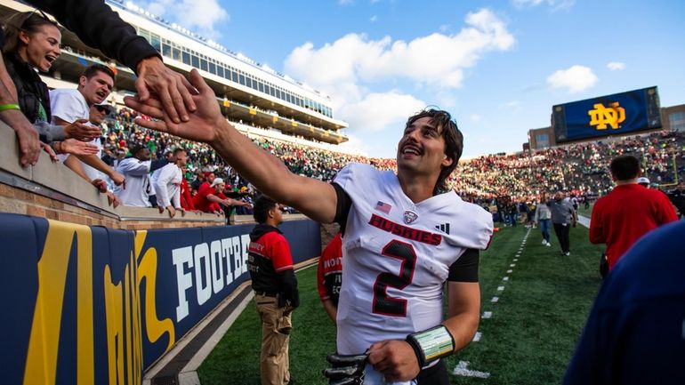 Northern Illinois quarterback Ethan Hampton (2) celebrates with fans after...